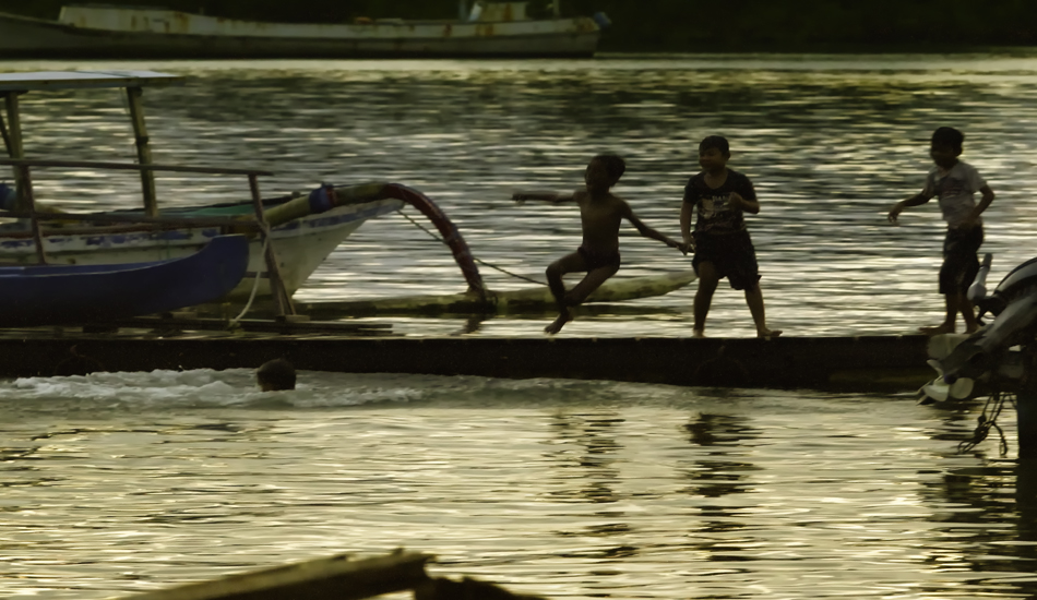 Children cooling off in the harbor at the end of a hot day. Benoa Harbor, Tanjung Benoa.
